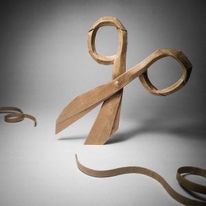 Origami of a pair of scissors cutting a ribbon.
