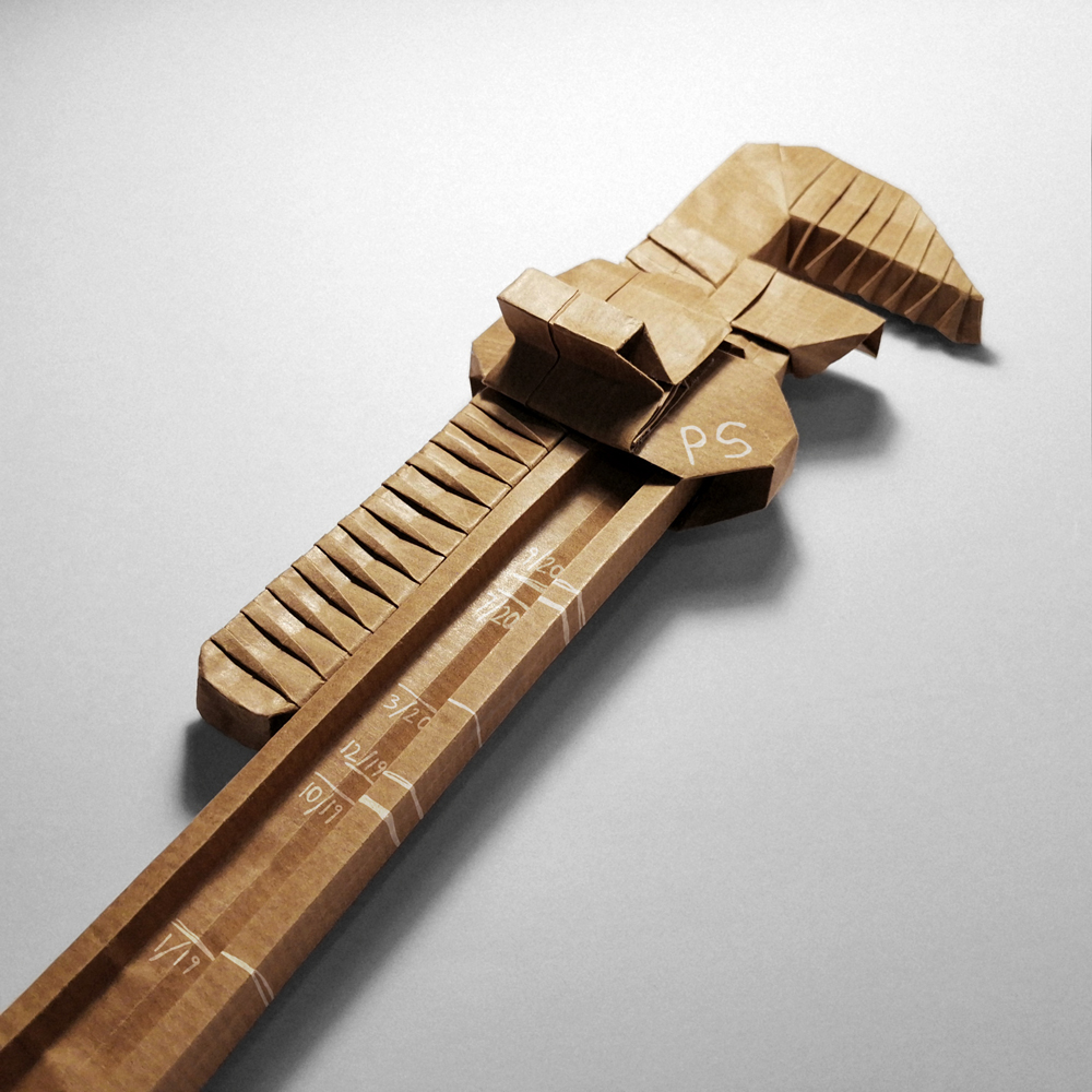 Origami of a pipe wrench with the progression of a child's height etched on it.